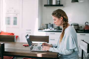 Woman works with laptop at home in the living room