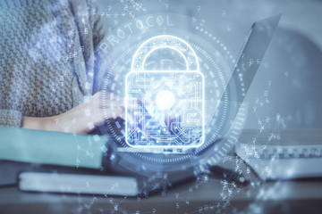 Double exposure of woman hands working on computer and lock hologram drawing. Security concept.