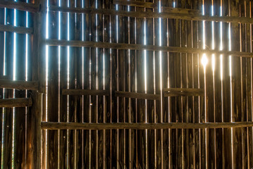 Sonnenstrahlen scheinen durch die Ritzen einer Bretterwand