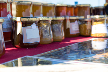 Selling homemade flower honey and honey products on the stand in the city park.