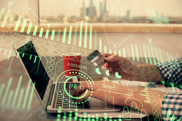 Double exposure of man hands holding a credit card and tech theme drawing. Technology in E-commerce...