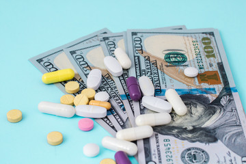 Healthcare cost concept. US Dollars with medicine pills. White pills spilling from medicine bottle. High Cost of Medicine and Healthcare. US Dollar Medicine