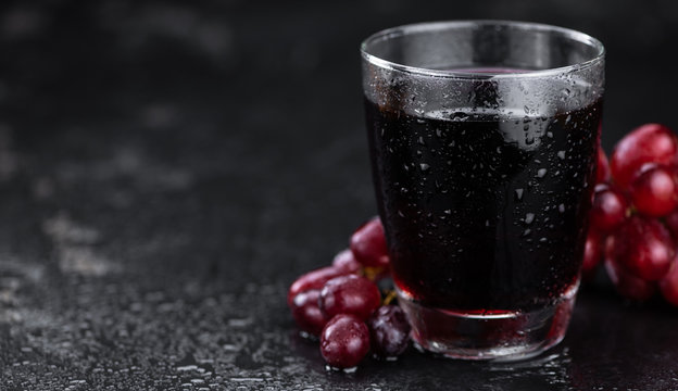 Portion of healthy Red Grape Juice (selective focus; close-up shot)