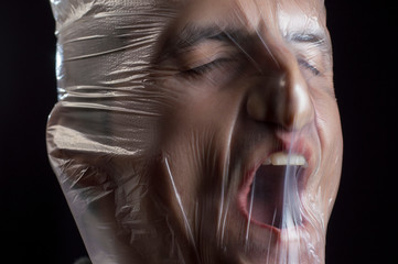 close-up portrait of a plastic bag on the face asphyxiation