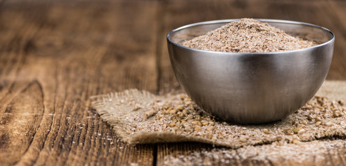 Vintage wooden table with Wheat Bran (selective focus; close-up shot)