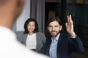 Smiling motivated middle-aged male employee raise hand volunteer at group office briefing or...
