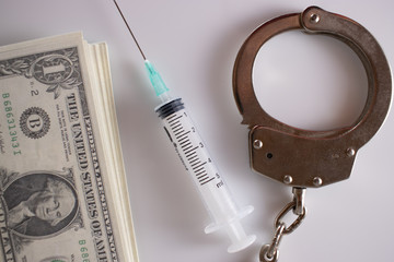 Punishment of narcotics traders. Amount of dollars,  syringes, handcuffs
