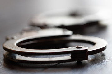 steel metal Handcuffs on brown background