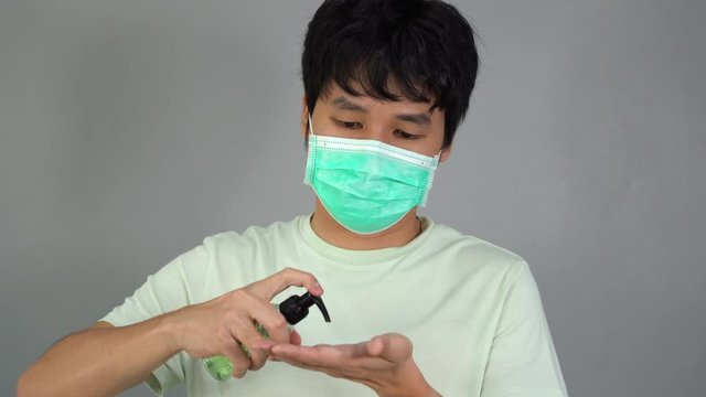 man in a medical mask(surgical mask) using alcohol gel, coronavirus protection