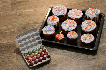 set of Easter cakes on a baking sheet and colored colored eggs in a box on a light surface. feast of the great Holy Easter.