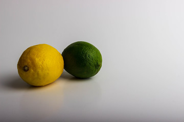 A delicious yellow lemon and green lime against a white background.