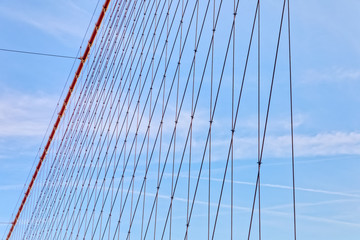 Fototapeta premium Brooklyn Bridge cable net against blue sky, New York