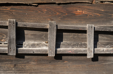 Old wooden ladder hanging on barn wall