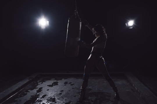 Professional image of Young sexy Woman boxer. Martial arts or self defence. Sport boxer woman in boxing in gloves makes a kick . Sport concept - Powered by Adobe