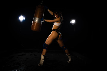 Young sexy Woman boxer. Martial arts or self defence. Sport boxer woman in boxing gloves makes a kick . Fitness girl training kick boxing. Boxing training on ring. Confident athlete woman in boxing gl