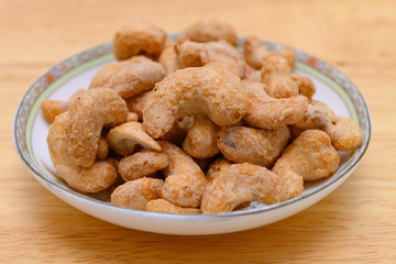 side view cashew nuts on a dish on wood background