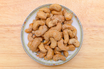 top view cashew nuts on a dish on wood background