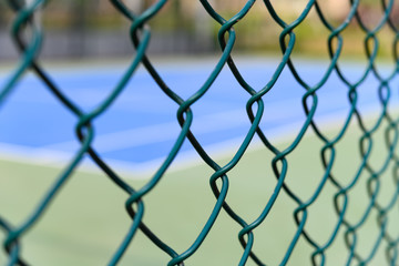 tennis court behine wire fence horizontal composition