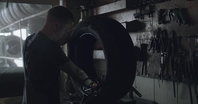 Mechanic skiving the tire patch in auto service