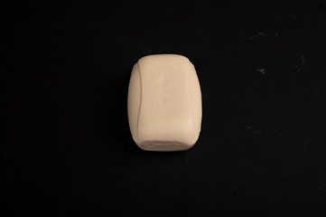 A piece of toilet soap on a black background. Close up. Thorough hand washing with soap is a prevention of COVID-19 infection.