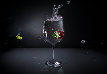 A strawberry falls into a cocktail glass
