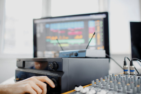 Male music arranger works with sound amplifier he is composing song on midi piano and audio equipment in digital recording studio. DJ in broadcasting studio. music, technology and equipment concept.