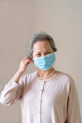 An old Asian woman wearing a mask