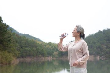 An old Asian woman drinking water