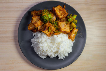 A plate of pad prik khing, thai red curry stir fried, with pork belly and white rice.