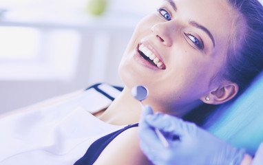 Young Female patient with open mouth examining dental inspection at dentist office.