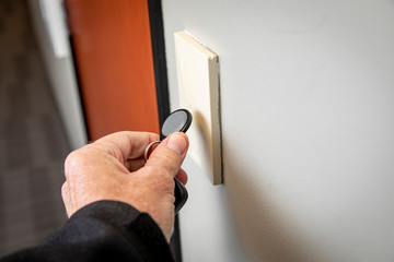 Close up of hand holding key FOB to gain access to an interior office door