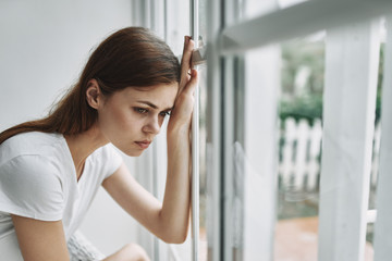 young woman looking out window