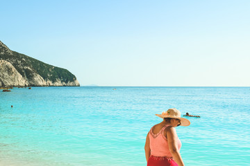 Beautiful woman walking on Porto Katskiki beach in Greece