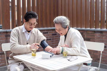 An old Asian couple using a sphygmomanometer