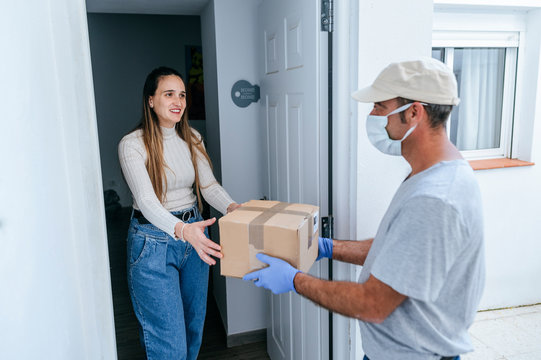 Delivery Man With Face Mask Delivering Package To Woman