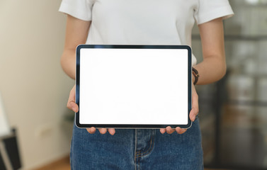 Closeup of woman standing and hand holding digital tablet with screen is blank on the office .