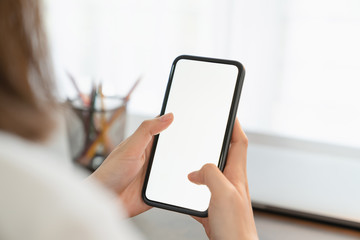 Closeup of young woman hand holding smartphone on the table and the screen is blank, social network concept.