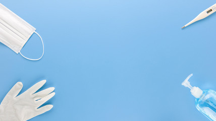 Medical supplies to stay safe and protect from COVID-19 top view with copy space on blue background