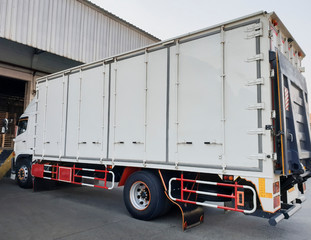 White truck cargo with lift parking at warehouse, road freight delivery logistics and transport.