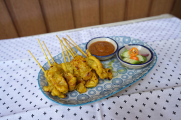 Pork Satay in the stick with Peanut Sauce serving with pickles which are cucumber slices and onions in vinegar