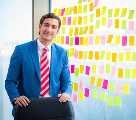 Young handsome employee with many conflicting priorities