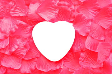 Floral Background concept for design of love card to holiday. Red silk petal of rose with empty white copy space in shape of heart in center. Top view 