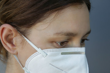 Close up portrait of young Caucasian woman wearing protective medical mask. COVID 19 novel Coronavirus outbreak or air pollution concept.	
