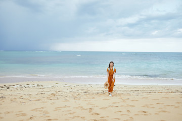 Fototapeta na wymiar young woman walking on the beach