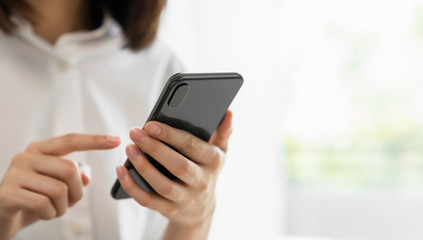 Close-up of hand holding smartphone device and  typing text message on online social.