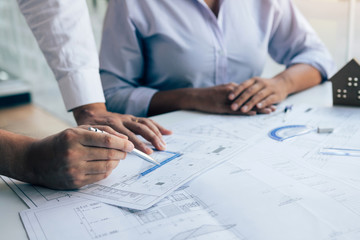 Team architect or engineering people discussion working on table together at a construction site.