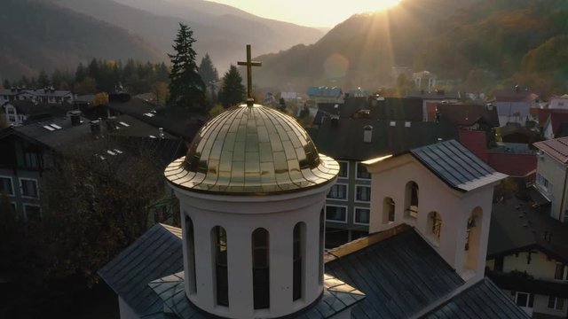 Aerial flight near with church at sunset in mountains in the Krasnaya Polyana of the city of Sochi