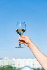 woman handing glass of white wine