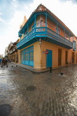 Fototapeta na wymiar Turquoise shutters on a historic landmark building and cobblestone street in Old Havana, Cuba