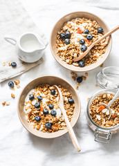 Homemade pumpkin granola with greek yogurt and blueberries on a light background, top view. Healthy  breakfast